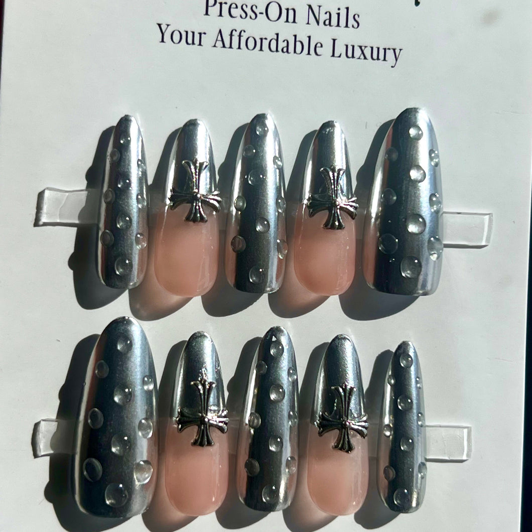 Long silver chrome gel nails with cross charm and raindrop look. wet look press on nails. silver chrome nails with charms