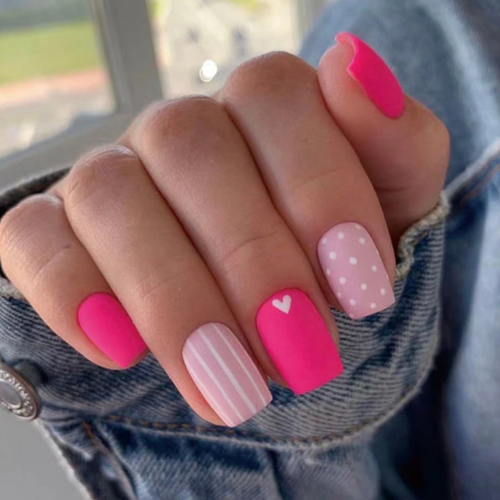 Short matte finish pink square nails with white stripes and polka dots